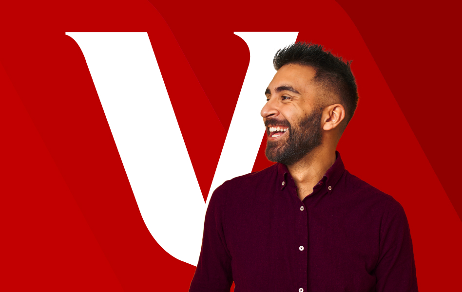 A man standing in front of a Vanguard “V” is smiling off into the distance.