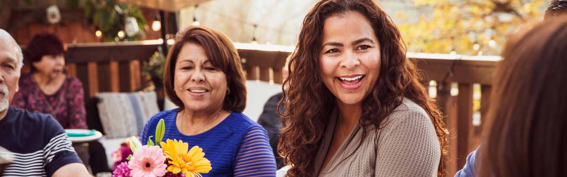 A young woman is smiling at someone in front of her.