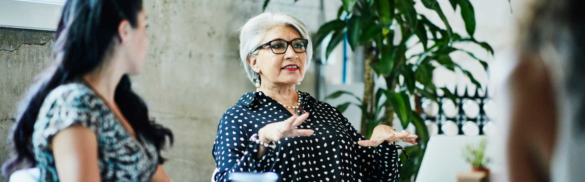 A woman is gesturing with her hands while looking forward at something out of the frame.