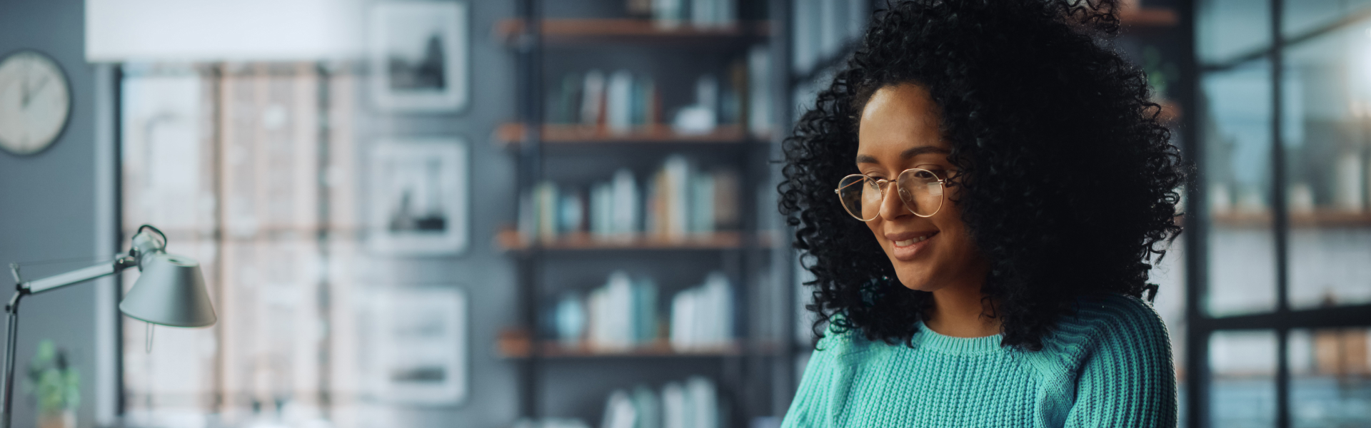 A young woman in an office is looking down at something in front of her.